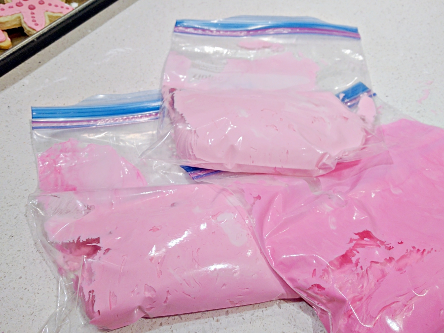 three shades of pink icing in baggies