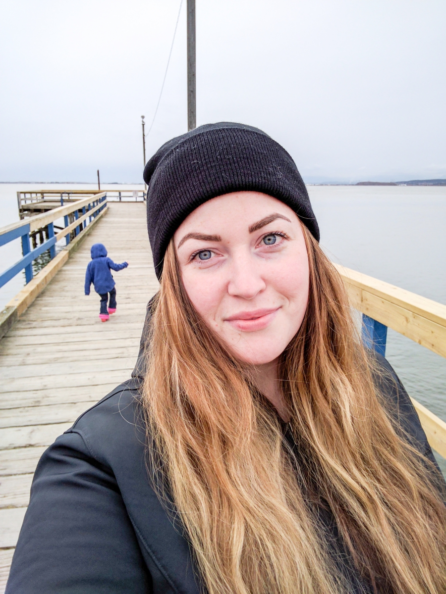 anxiety: pier stretching out to the ocean, close up of a women wearing a toque